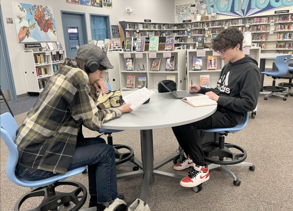Students lounge in the UHS Library, reading books. The library offers a wide assortment of genres to choose from, including nonfiction, fantasy, history fiction, dystopian and more.